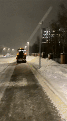 Snow removal vehicle operates on Nizhnevartovsk street at night