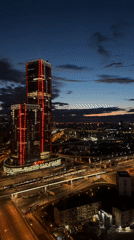 Evening cityscape observed in Khimki featuring illuminated skyscraper