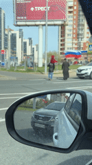 Pedestrians carry red and Russian flags crossing Saint Petersburg street