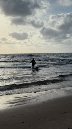 Person and dog enjoy ocean time at Bat Yam beach
