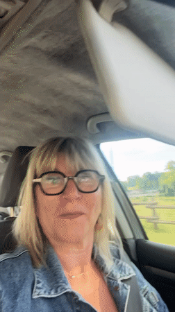 Woman makes playful faces while seated in car in Chambœuf