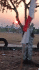 Loaded motorcycle heads down a rural Indonesian road at sunset.