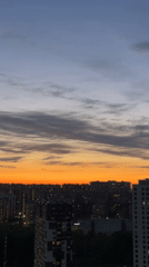 Dusk settles over Kudrovo cityscape with illuminated buildings