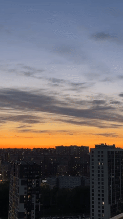 Dusk settles over Kudrovo cityscape with illuminated buildings