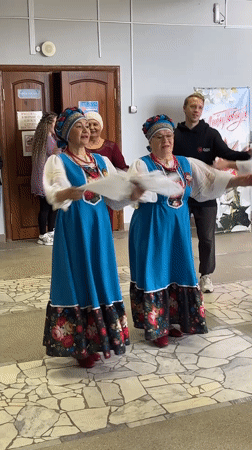 Folk dancers perform in traditional costumes in Elovo hallway