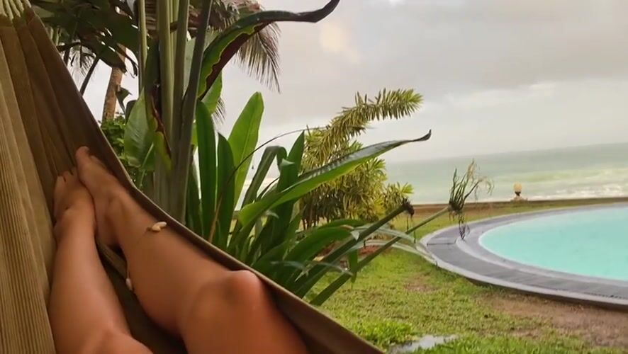 Person relaxes in hammock amid tropical foliage in Sri Lanka
