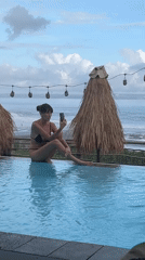 Woman photographs resort pool scene in Mengwi, Indonesia