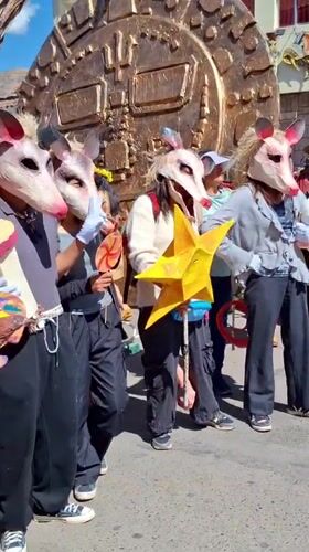 Folkloric festival parade with animal masks and creature float in Cuzco