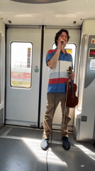 Street musician performs with violin at Spanish train station