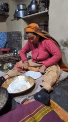 Woman prepares traditional meal in Haini kitchen