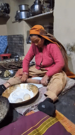 Woman prepares traditional meal in Haini kitchen