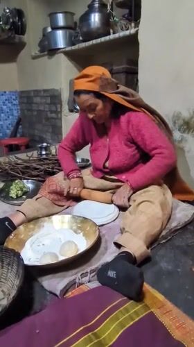 Woman prepares traditional meal in Haini kitchen