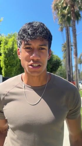 Man films video content on Beverly Hills residential street