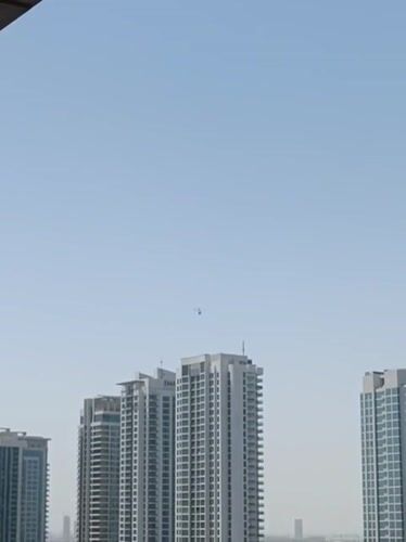 Helicopter spotted over Dubai cityscape and parking areas
