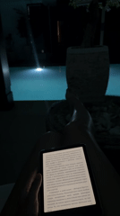 Person reads Russian text on tablet by pool in Kuta