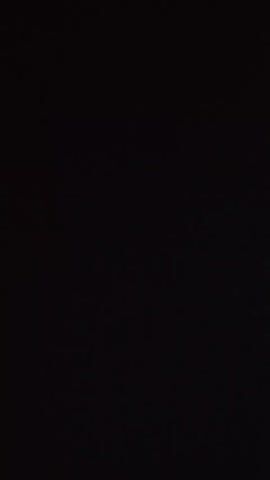 A very dark, low-resolution video begins with a black screen. At 00:00:01, a voice asks "You..." At 00:00:02, another voice says "What are you doing?" At 00:00:03, the first voice says "Filming." At 00:00:04, the video shows a black screen with a faint light in the distance.