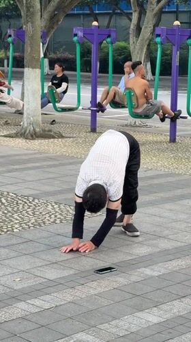 Man performs early morning stretching routine in Jiangjin park