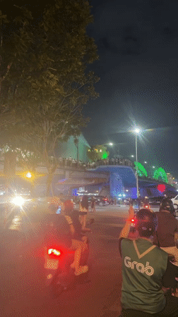 Nighttime dancing and dragon bridge spectacle captured in urban setting