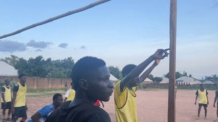 Young men play soccer on dirt field in Jalingo