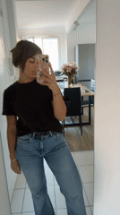 Woman takes selfies in Cannes hallway during afternoon