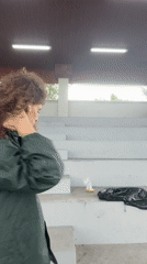 Woman in raincoat visits soccer facility during rain in Indonesia