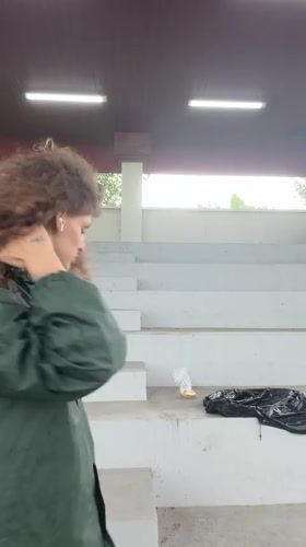Woman in raincoat visits soccer facility during rain in Indonesia