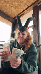 Woman in horned headpiece photographed with cash in Chaikovsky
