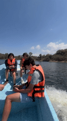 Young people enjoy boating with life vests at Mexican lake