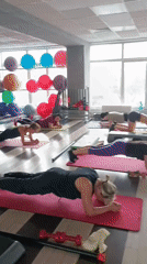 Women practice plank exercises in Moscow fitness studio