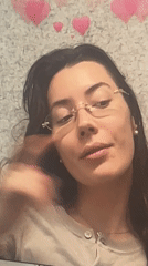 Woman makes shushing gesture while multitasking on laptop in Dubai