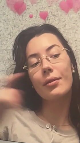 Woman makes shushing gesture while multitasking on laptop in Dubai