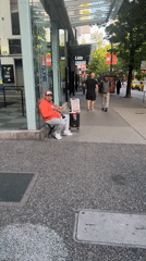 Street musician performs clarinet on Vancouver sidewalk
