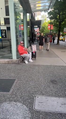 Street musician performs clarinet on Vancouver sidewalk
