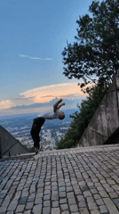 Man performs backflip on elevated stone surface in Shumen