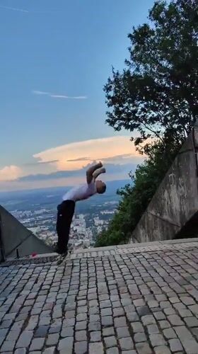 Man performs backflip on elevated stone surface in Shumen
