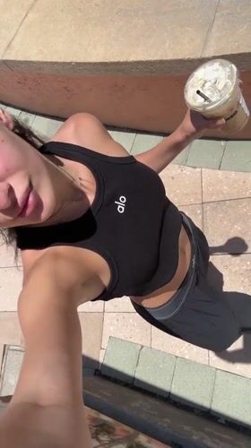 Woman in activewear takes selfies near Boca Raton pavilion