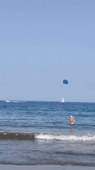 Sunny morning at Costa Adeje beach with parasailing offshore