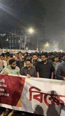 Nighttime protest crowds Dhaka streets near Shaheed Minar