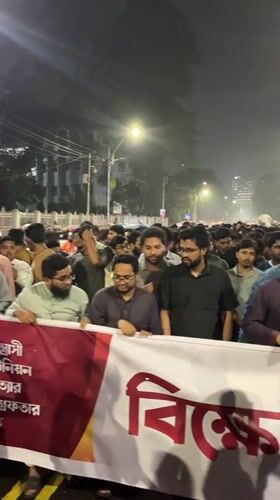 Nighttime protest crowds Dhaka streets near Shaheed Minar