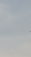 Parachutists descend over a quiet Bulgarian village on a grey morning