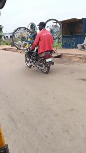 Man carries two bicycles on moped in Nigeria
