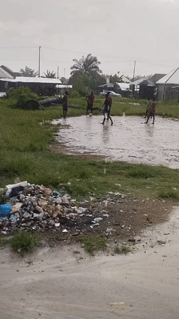 Young men play soccer in flooded field in Nigeria