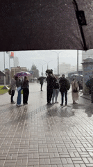 Heavy precipitation brings umbrellas to Belarus street scene