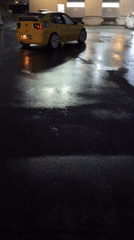 Yellow rally car performs nighttime donuts in Burgas parking lot