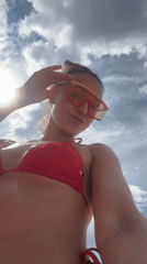 Woman films beach selfies in red bikini, Kazan