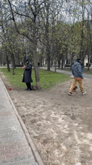 Street musician performs in Saint Petersburg park during overcast afternoon