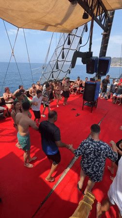 Party dancing on a red-carpeted boat deck in Alanya