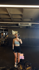 Woman films workout selfie in Bat Yam gym mirror