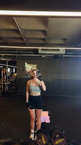 Woman films workout selfie in Bat Yam gym mirror