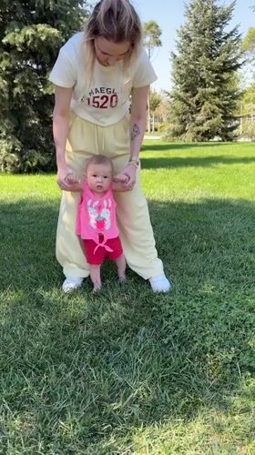 Woman teaches baby to walk in Krasnodar park